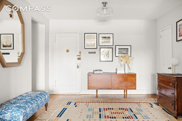 entryway with baseboards and wood finished floors