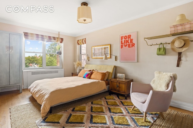 bedroom with wood finished floors and radiator heating unit