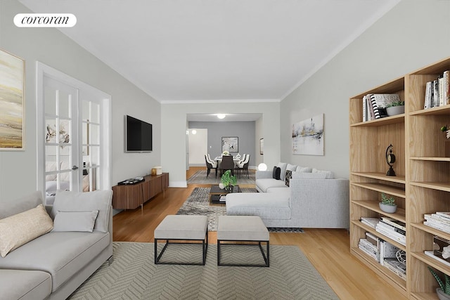 living room with light wood-type flooring, visible vents, and crown molding