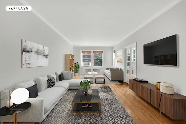 living room featuring light wood finished floors, visible vents, and crown molding