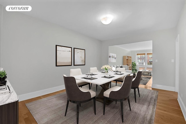 dining room with light wood-type flooring, baseboards, and visible vents
