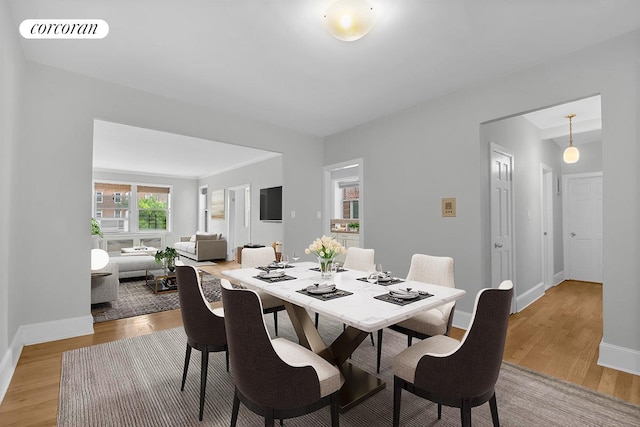 dining space with visible vents, light wood-style flooring, and baseboards