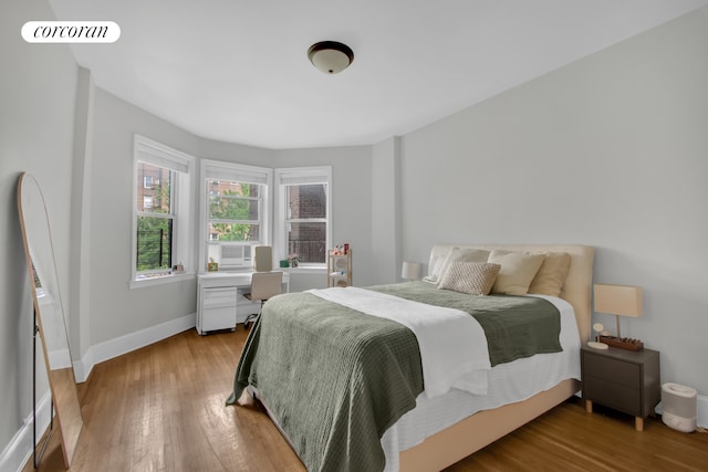 bedroom featuring visible vents, baseboards, and wood finished floors