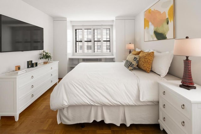 bedroom featuring radiator heating unit and dark parquet floors