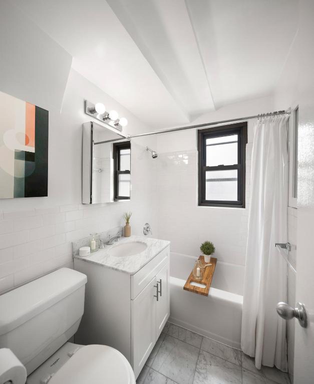 full bathroom with toilet, tile walls, vanity, and shower / tub combo with curtain