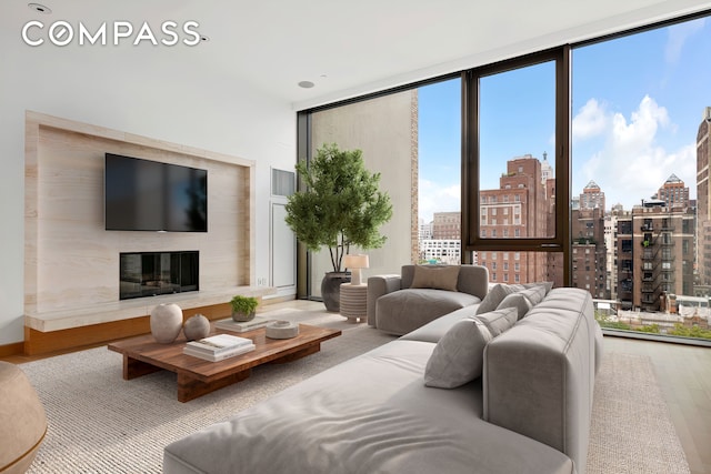 living area featuring a wall of windows, wood finished floors, and a premium fireplace