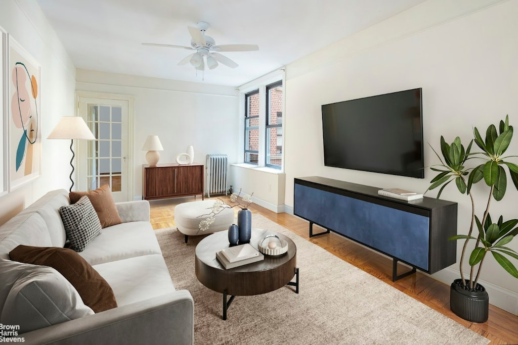 living room featuring ceiling fan, radiator, and hardwood / wood-style flooring