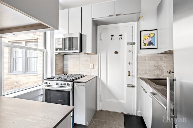 kitchen with white cabinetry, appliances with stainless steel finishes, and backsplash