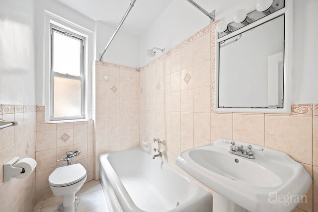 full bathroom featuring shower / bathing tub combination, sink, tile walls, tile patterned flooring, and toilet