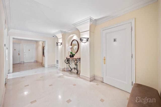 foyer with light tile patterned floors, ornamental molding, and decorative columns