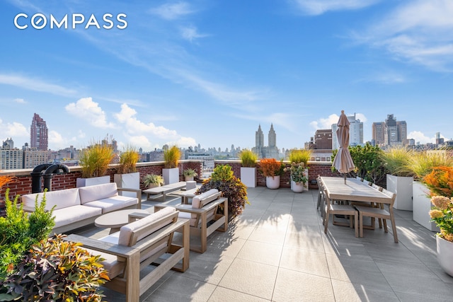 view of patio / terrace featuring a view of city, outdoor dining area, and an outdoor living space