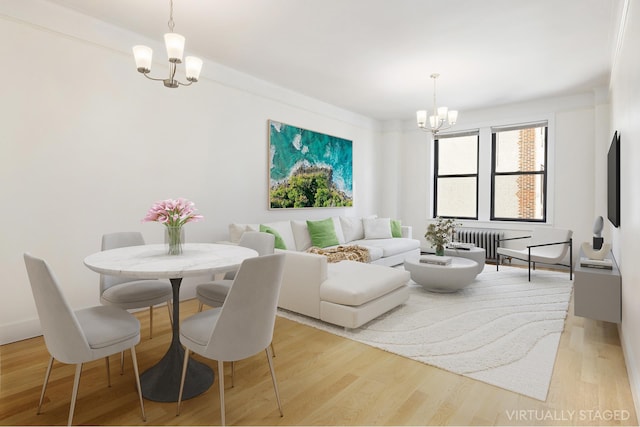 dining space featuring a notable chandelier, light wood-style flooring, and radiator heating unit