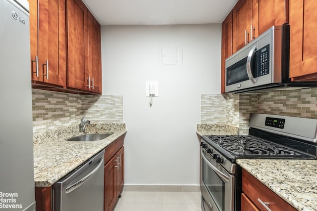 201 E 28th St Unit 17C, New York City, NY 10016 - kitchen featuring stainless steel appliances, light stone counters, backsplash, and light tile patterned floors
