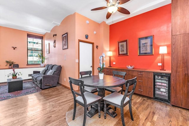 dining room with ceiling fan, beverage cooler, and hardwood / wood-style floors