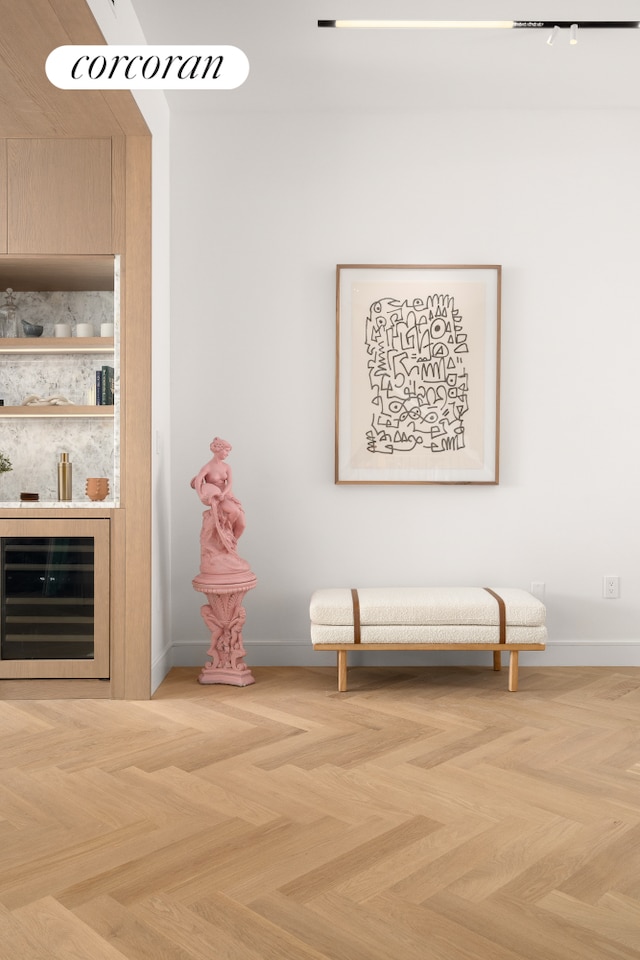 interior space featuring a bar, beverage cooler, and baseboards