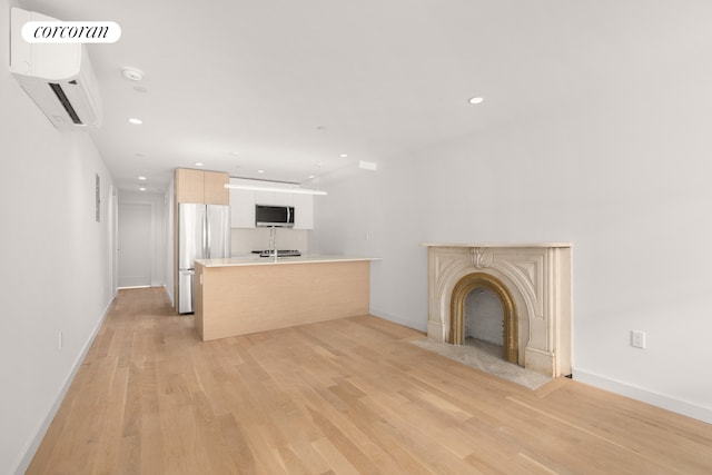 unfurnished living room with light wood-style flooring, a fireplace, baseboards, and recessed lighting