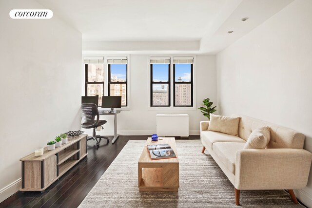 living room featuring dark wood-style flooring, visible vents, and baseboards