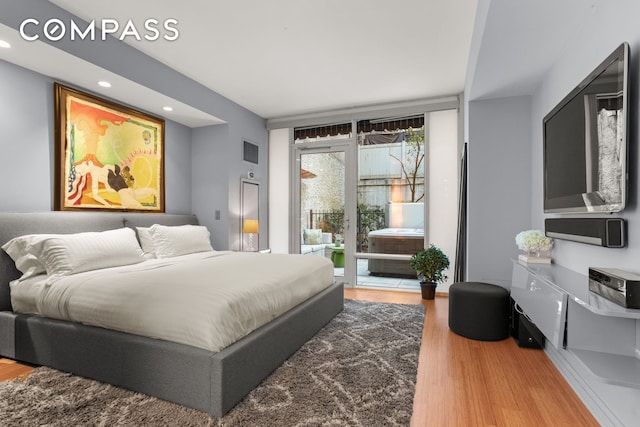 bedroom with access to outside, visible vents, wood finished floors, and recessed lighting