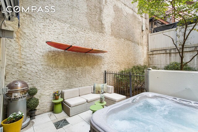 view of patio / terrace with fence and a hot tub