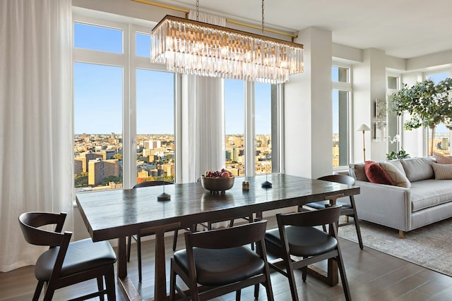 dining area with dark wood-type flooring and a notable chandelier