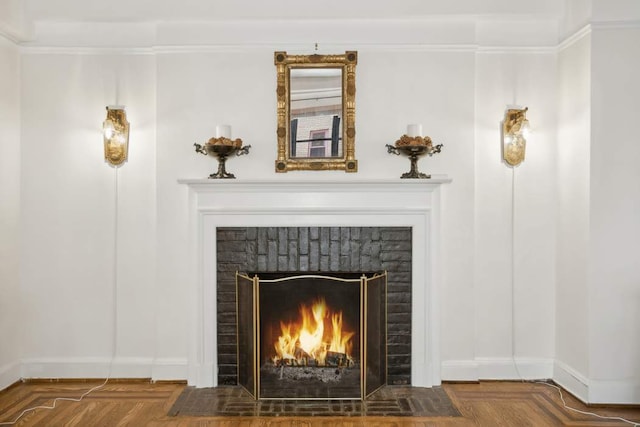 details with a brick fireplace, baseboards, and ornamental molding