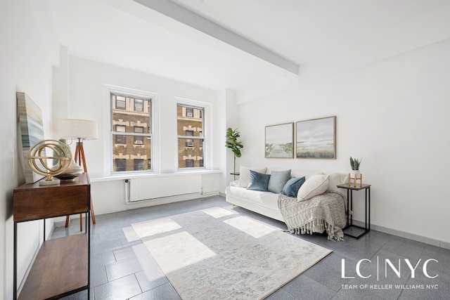 living room featuring radiator heating unit, baseboards, and beamed ceiling