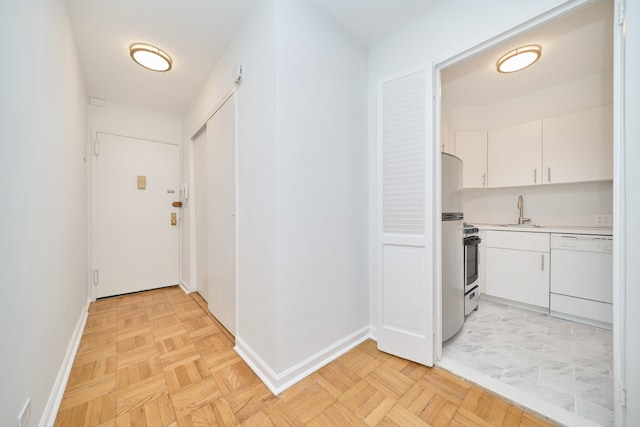 hallway with a sink and baseboards