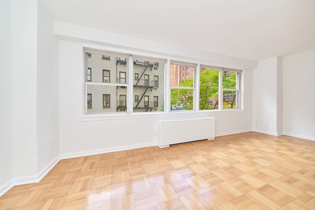 spare room with radiator and baseboards