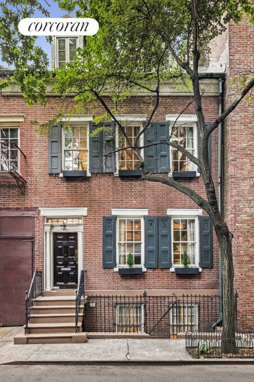 view of property featuring entry steps and brick siding