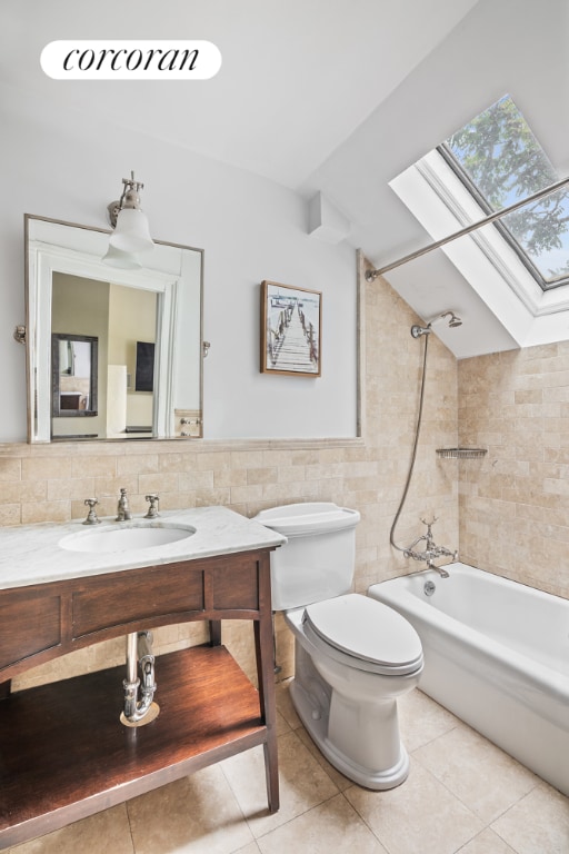 full bath with tile walls, shower / bathtub combination, lofted ceiling with skylight, a sink, and tile patterned floors