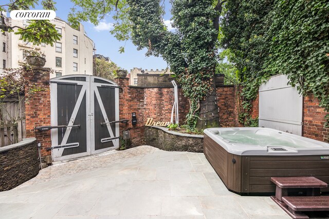 view of patio / terrace featuring a hot tub and fence