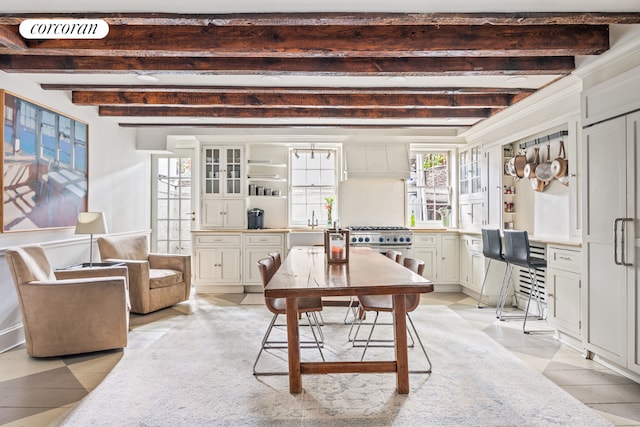 dining area featuring built in desk, visible vents, and beam ceiling