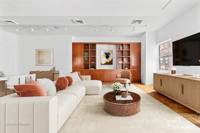 living room featuring visible vents and wood finished floors