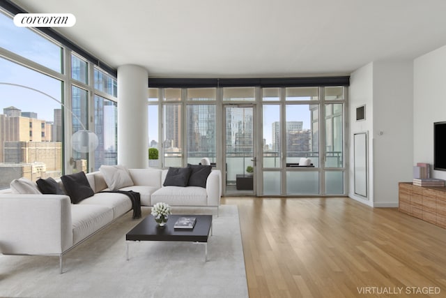 living room with light hardwood / wood-style floors and a wall of windows