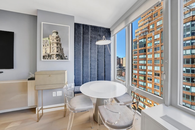 dining area featuring a view of city, wood finished floors, and baseboards