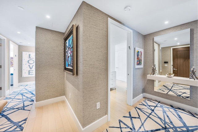 hallway with baseboards, light wood finished floors, recessed lighting, and wallpapered walls