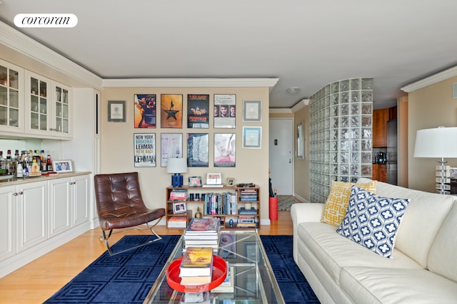 living area with visible vents, crown molding, a bar, and wood finished floors