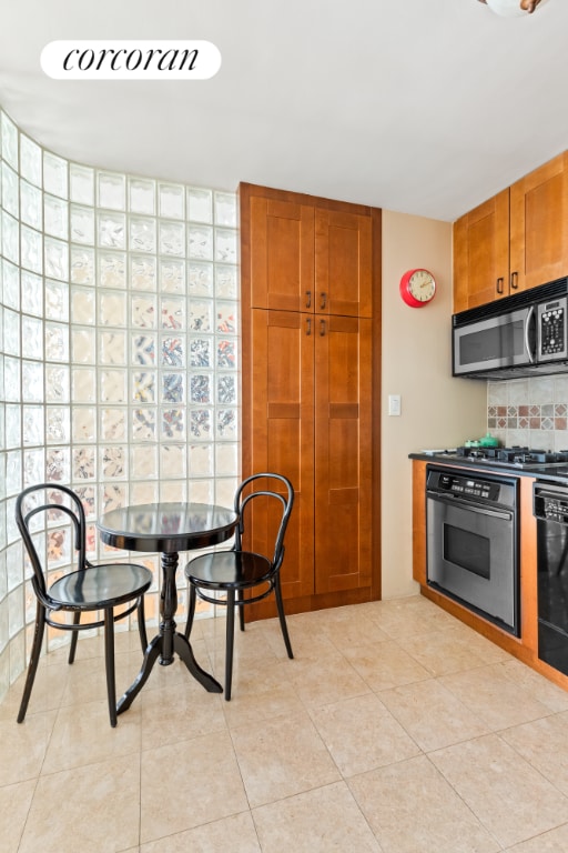 kitchen featuring tasteful backsplash, appliances with stainless steel finishes, and light tile patterned floors