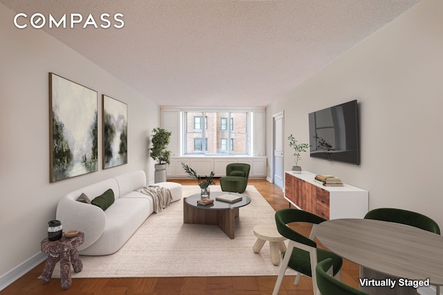 living area with baseboards and a textured ceiling