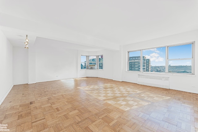 empty room with radiator and light parquet flooring