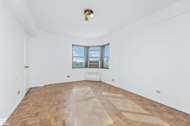 unfurnished room featuring radiator and light parquet flooring