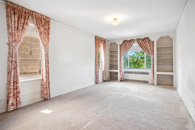 empty room featuring radiator and carpet floors