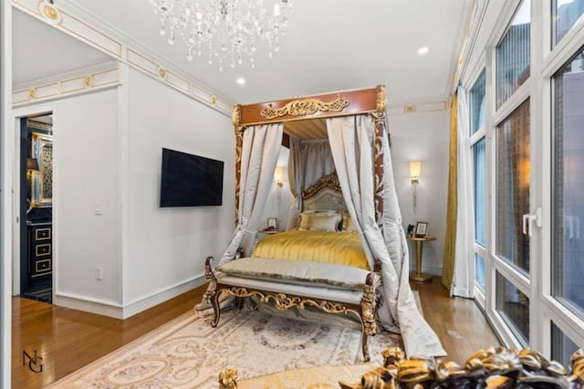 bedroom featuring dark hardwood / wood-style floors, ornamental molding, and an inviting chandelier