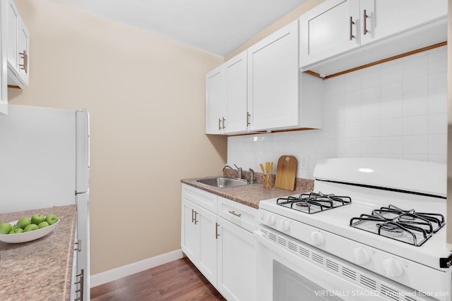 kitchen with white appliances, tasteful backsplash, dark wood-style flooring, white cabinetry, and a sink