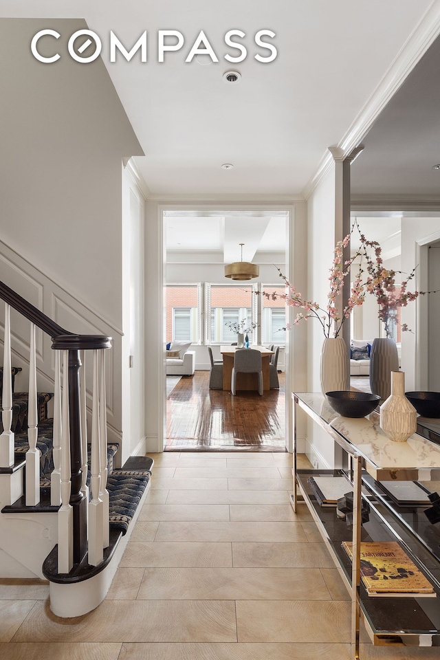 corridor with wood finish floors, stairway, and ornamental molding