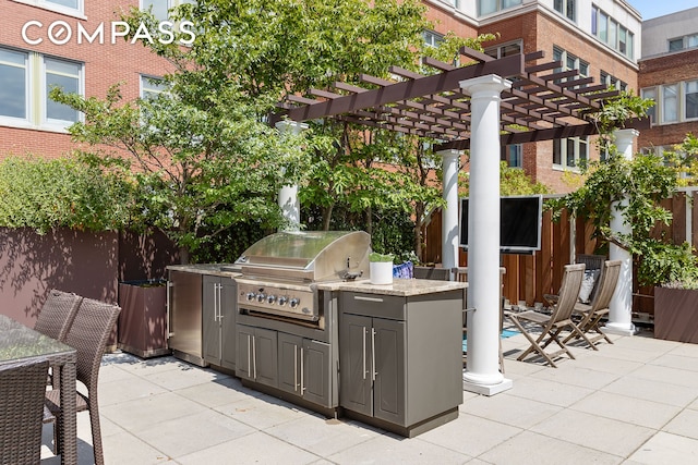 view of patio with grilling area, an outdoor kitchen, a pergola, and fence