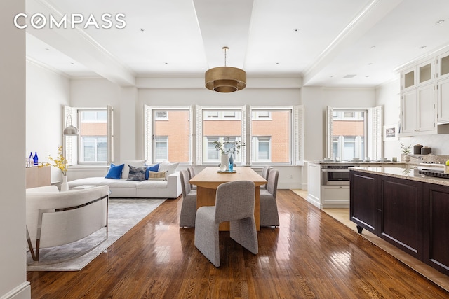 dining area featuring baseboards, wood-type flooring, and ornamental molding