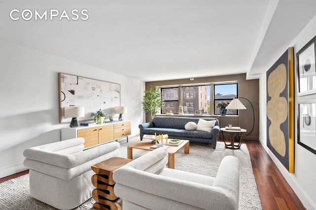 living room featuring dark wood-type flooring and baseboards