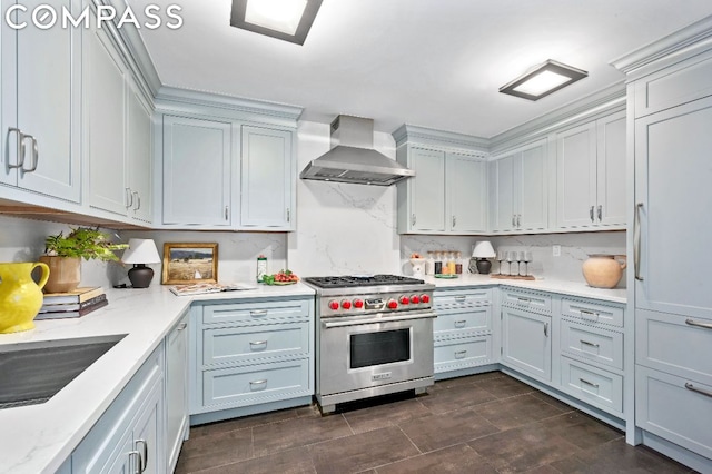 kitchen featuring luxury stove, exhaust hood, and sink