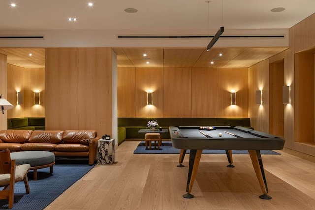 recreation room featuring billiards, light hardwood / wood-style floors, and wood walls